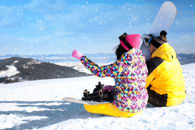 Photo of Couple with snowboards on hill, space for text. Winter vacation