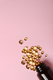 Photo of Bottle with cod liver oil capsules on color background, flat lay. Space for text