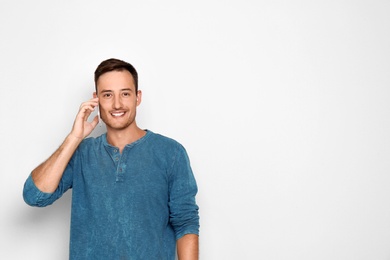 Photo of Young man talking on phone against white background. Space for text