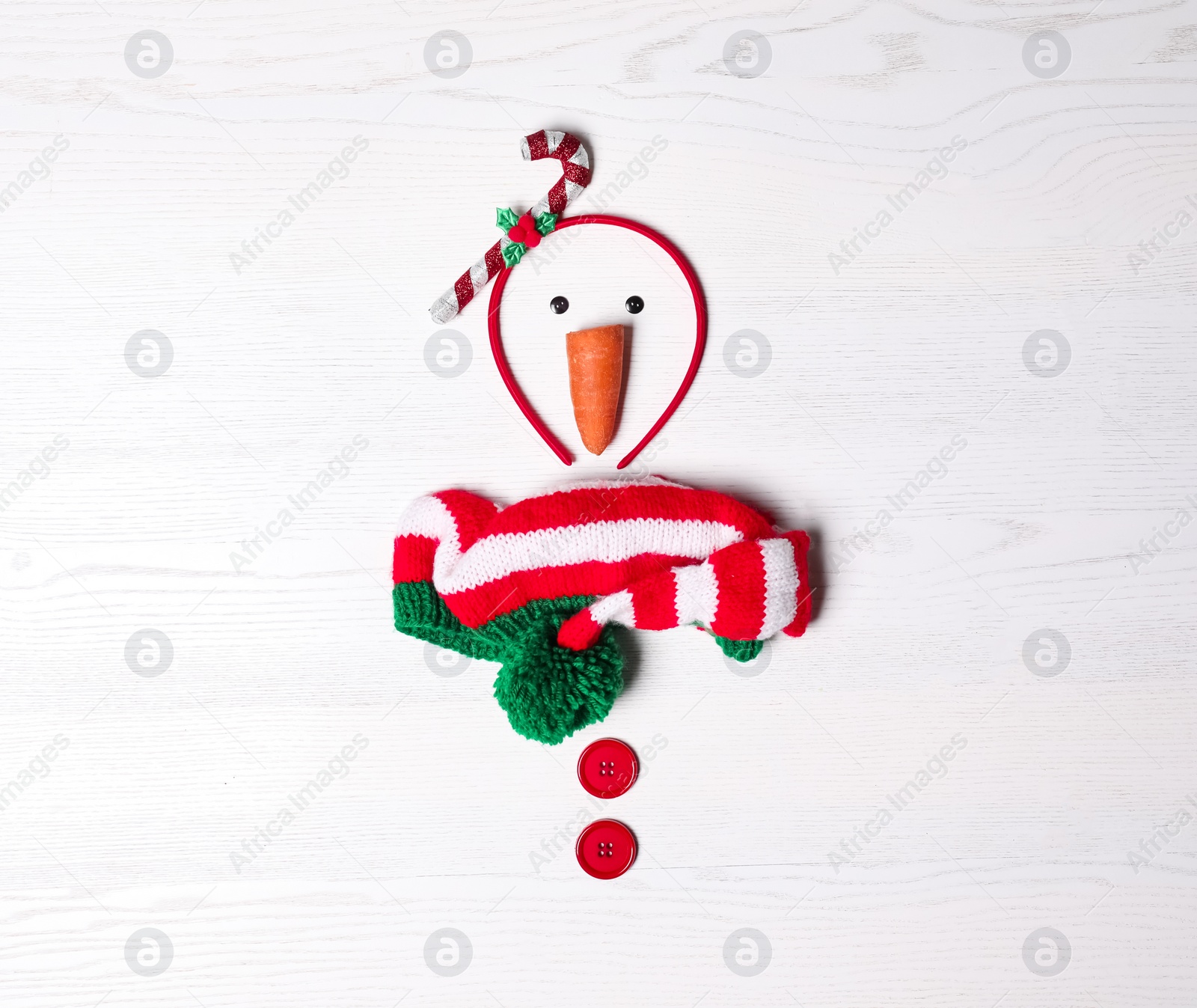 Photo of Funny snowman made with different elements on white wooden background, flat lay