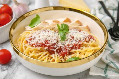Photo of Delicious pasta with tomato sauce, chicken and parmesan cheese on white marble table, closeup