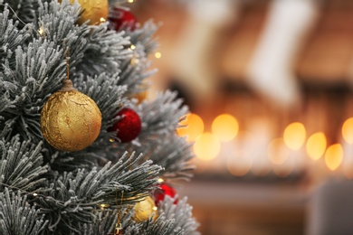 Beautiful Christmas tree decorated with balls against blurred festive lights, closeup. Space for text