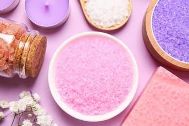 Photo of Sea salt and different spa products on pink background, flat lay