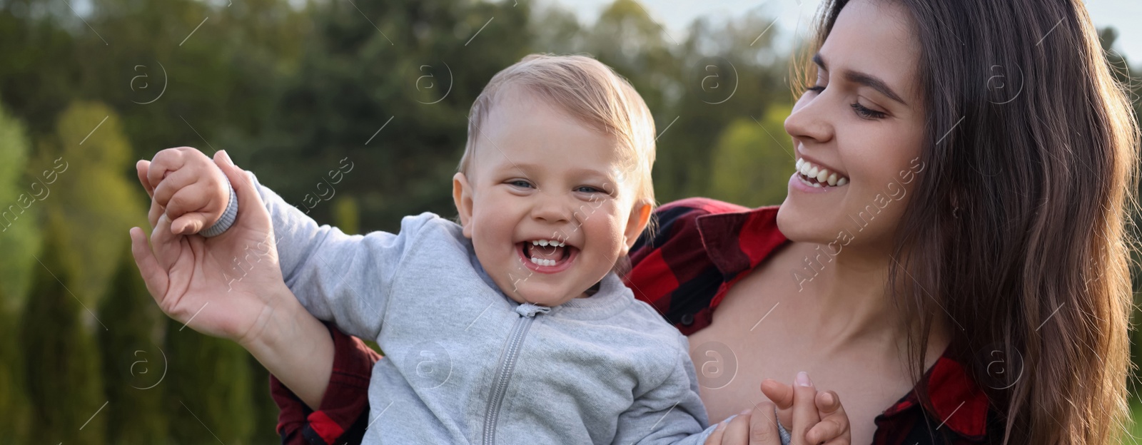 Image of Happy mother with her cute baby in park on sunny day. Banner design