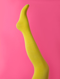 Photo of Leg mannequin in yellow tights on pink background