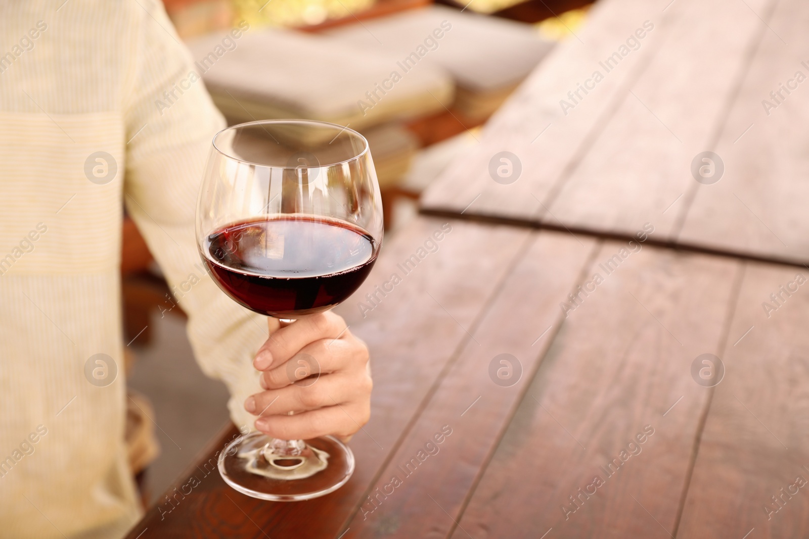 Photo of Woman with glass of red wine in outdoor cafe, closeup. Space for text