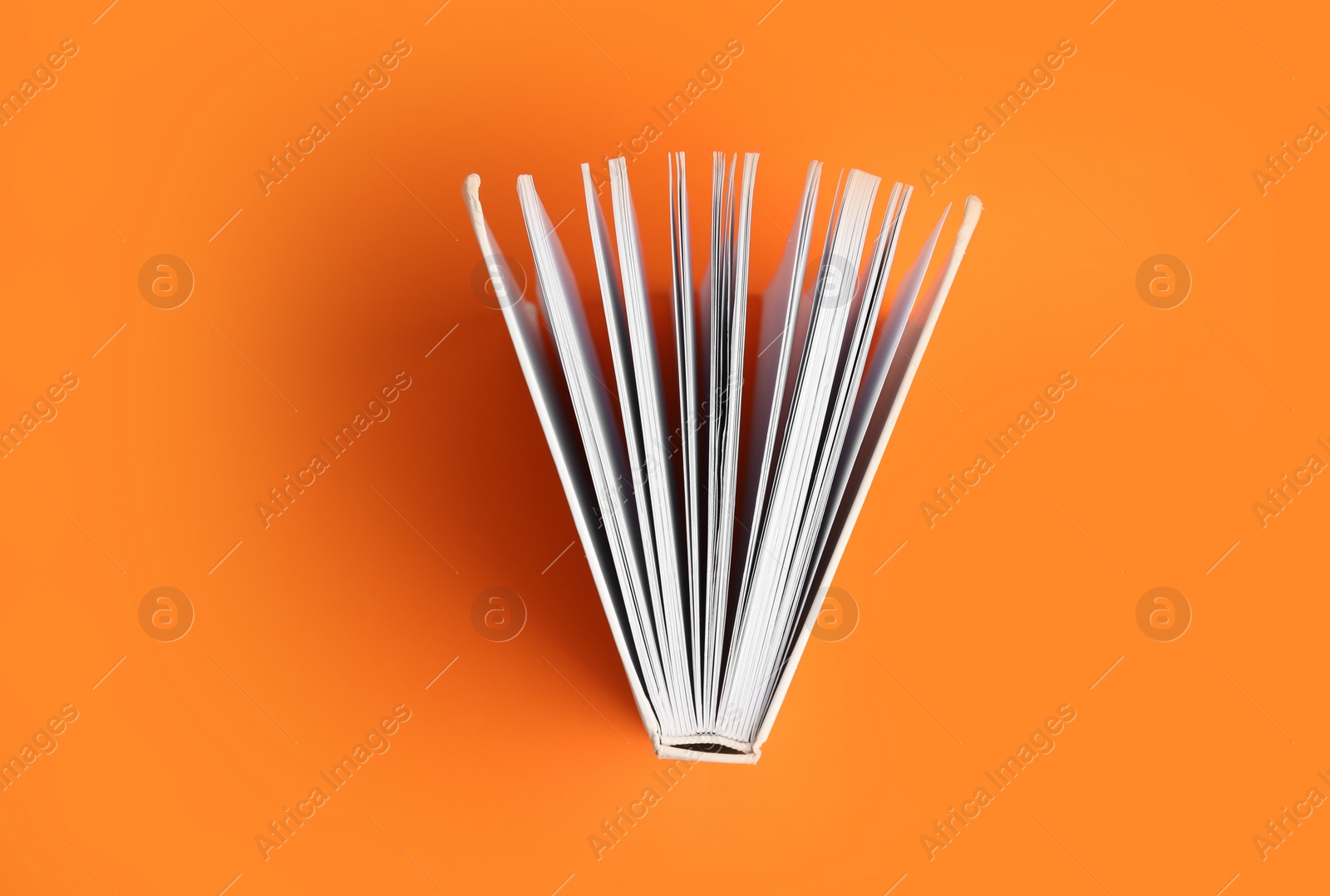 Photo of Hardcover book on orange background, top view