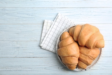 Photo of Plate with tasty croissants on wooden table