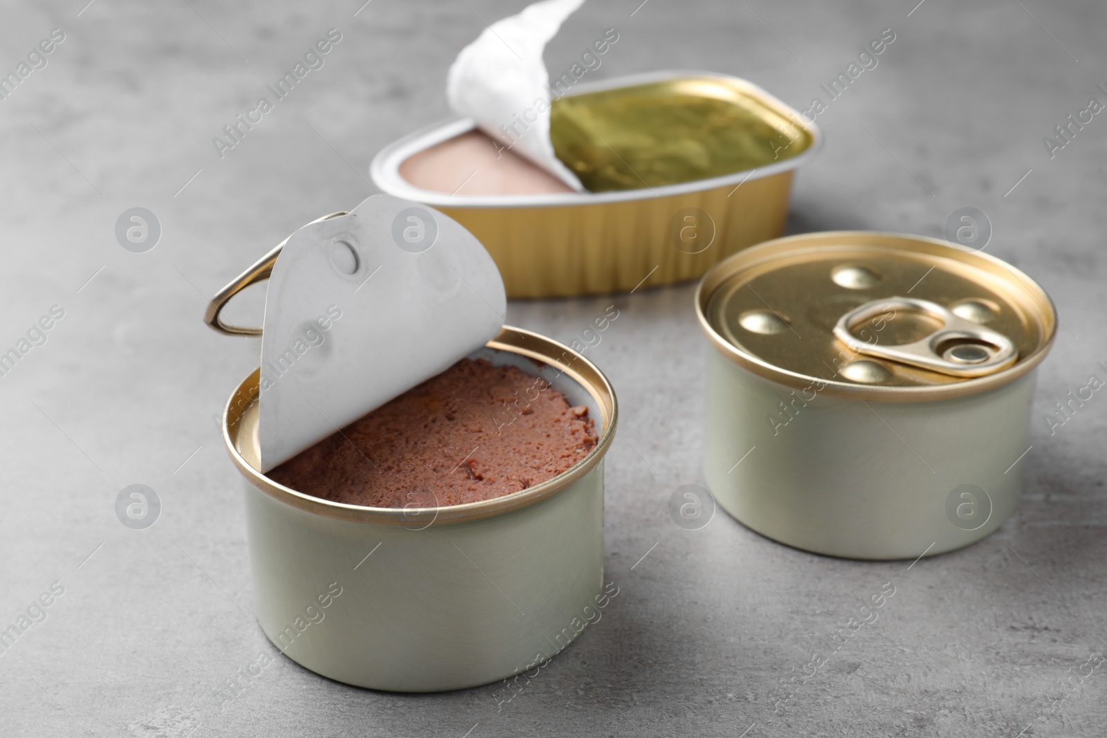 Photo of Tin cans of wet pet food on grey table