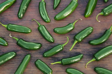 Many fresh green jalapeno peppers on wooden table, flat lay