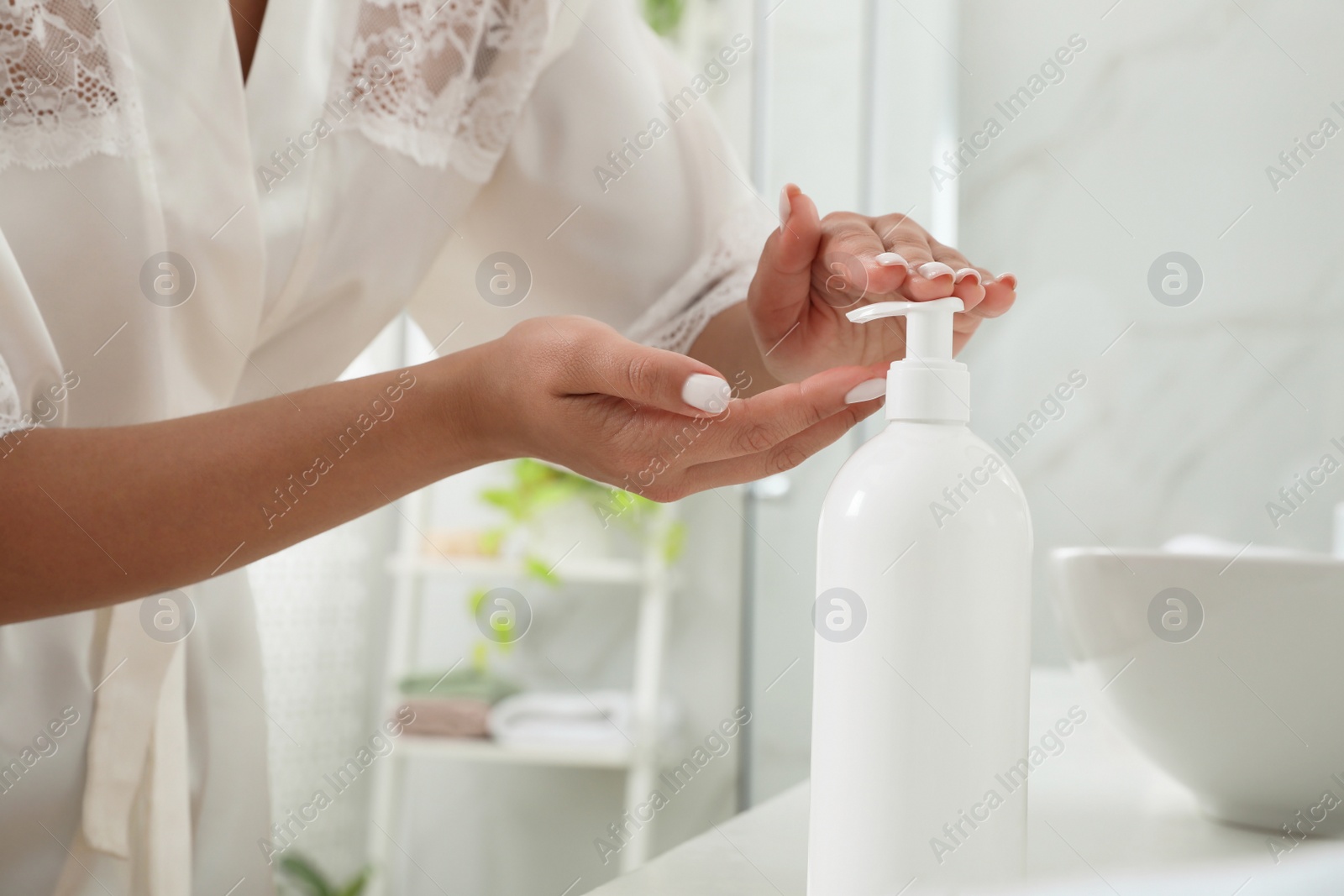 Photo of Beautiful young woman using washing gel in bathroom, closeup. Skin care cosmetic