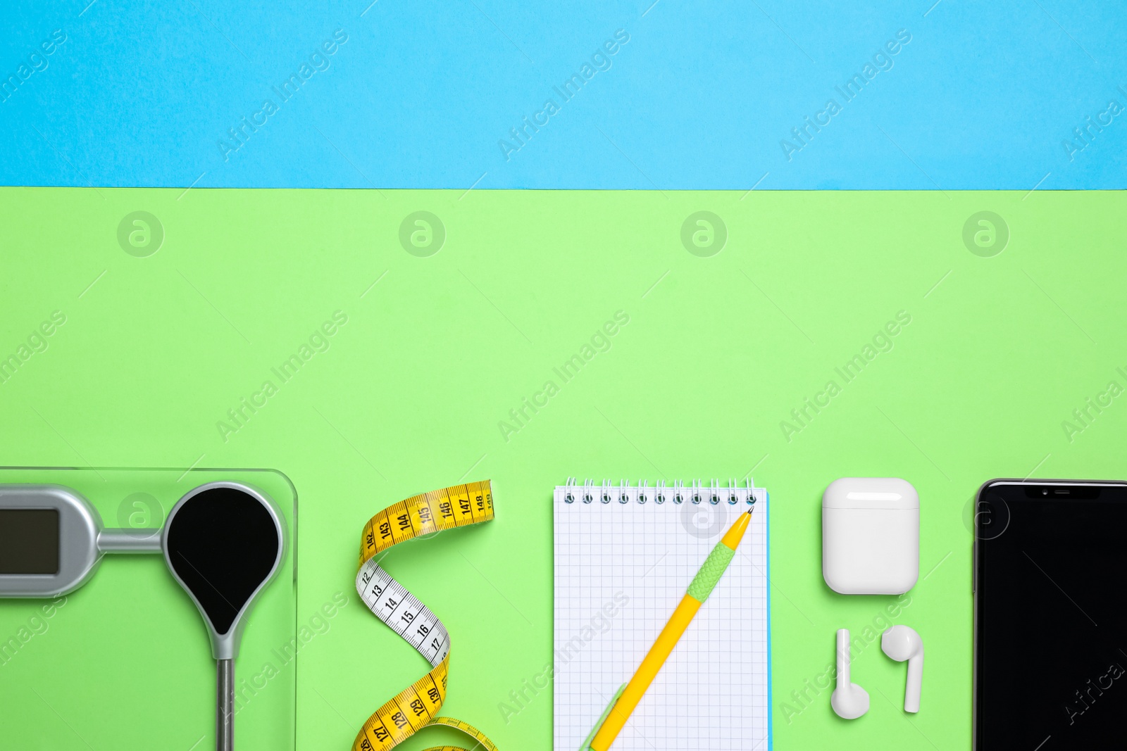 Photo of Flat lay composition with scale, measuring tape, notebook on color background. Space for text