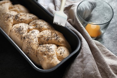 Homemade braided bread and ingredients on grey table. Cooking traditional Shabbat challah