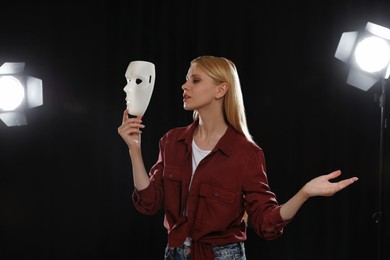 Photo of Professional actress rehearsing with mask on stage in theatre