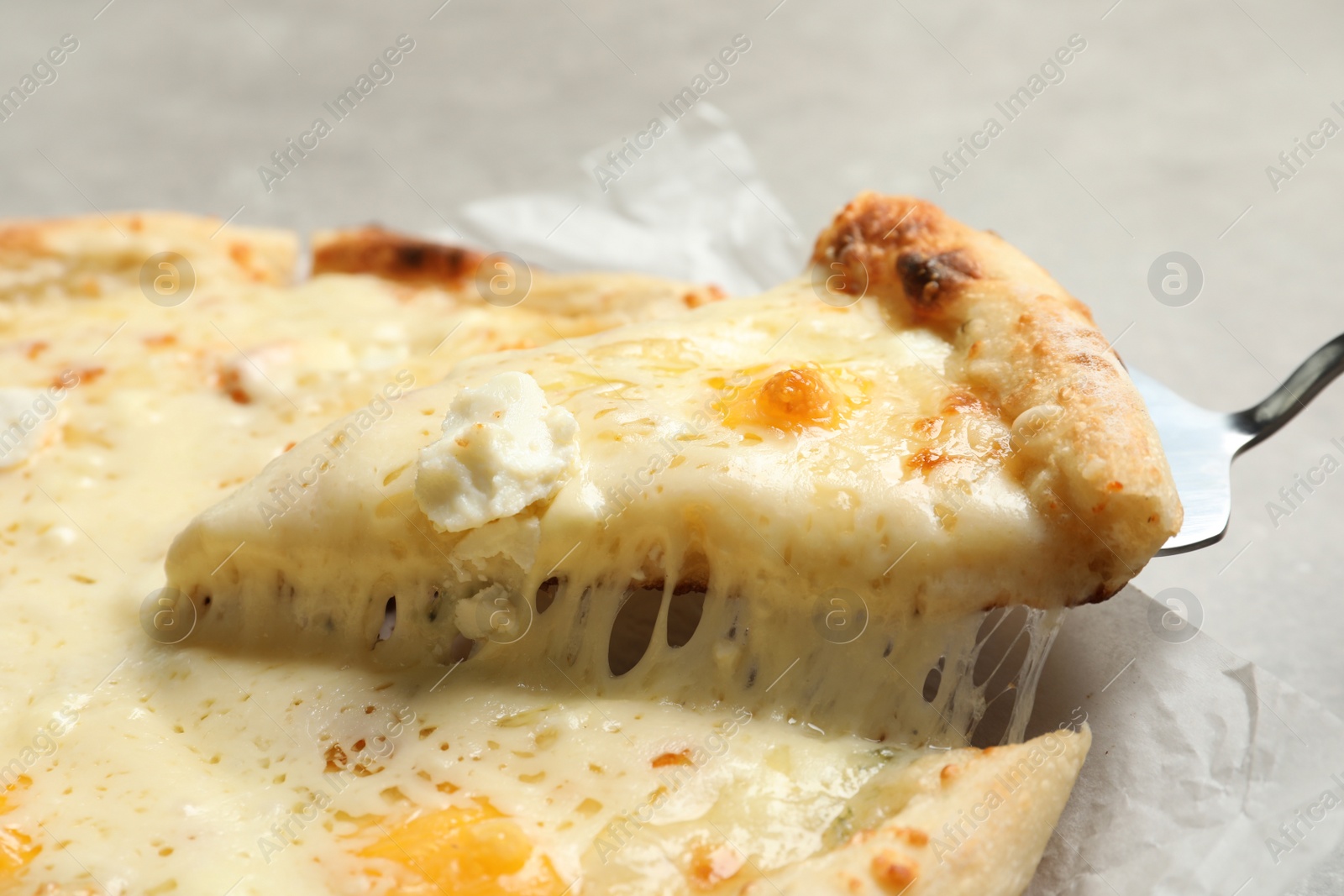 Photo of Taking slice of hot cheese pizza Margherita on table, closeup