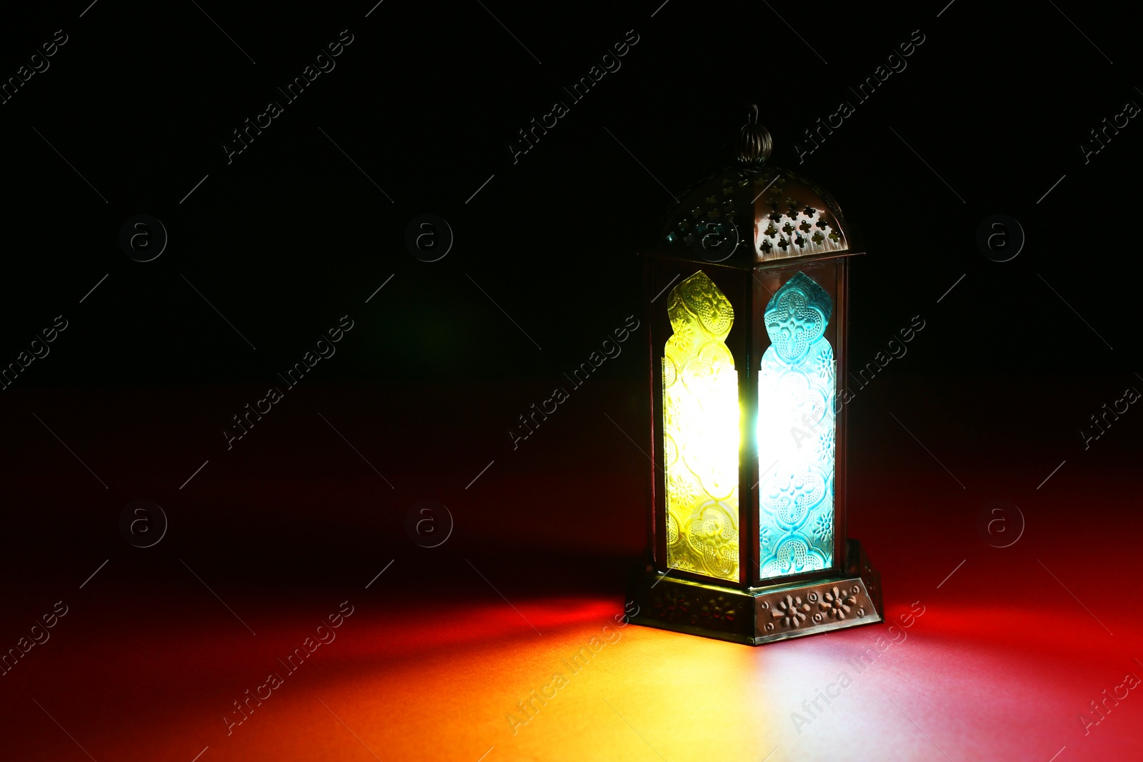 Photo of Decorative Arabic lantern on table against dark background. Space for text