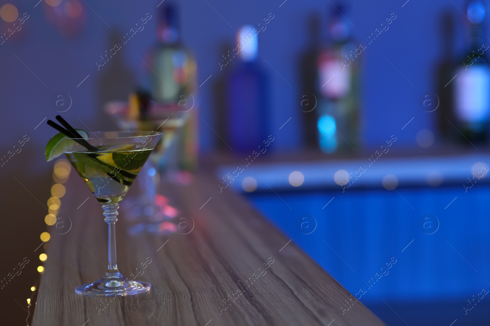 Photo of Delicious lime martini on table in bar, space for text