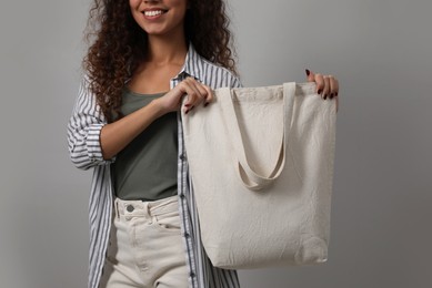 Happy African-American woman with eco bag on grey background, closeup