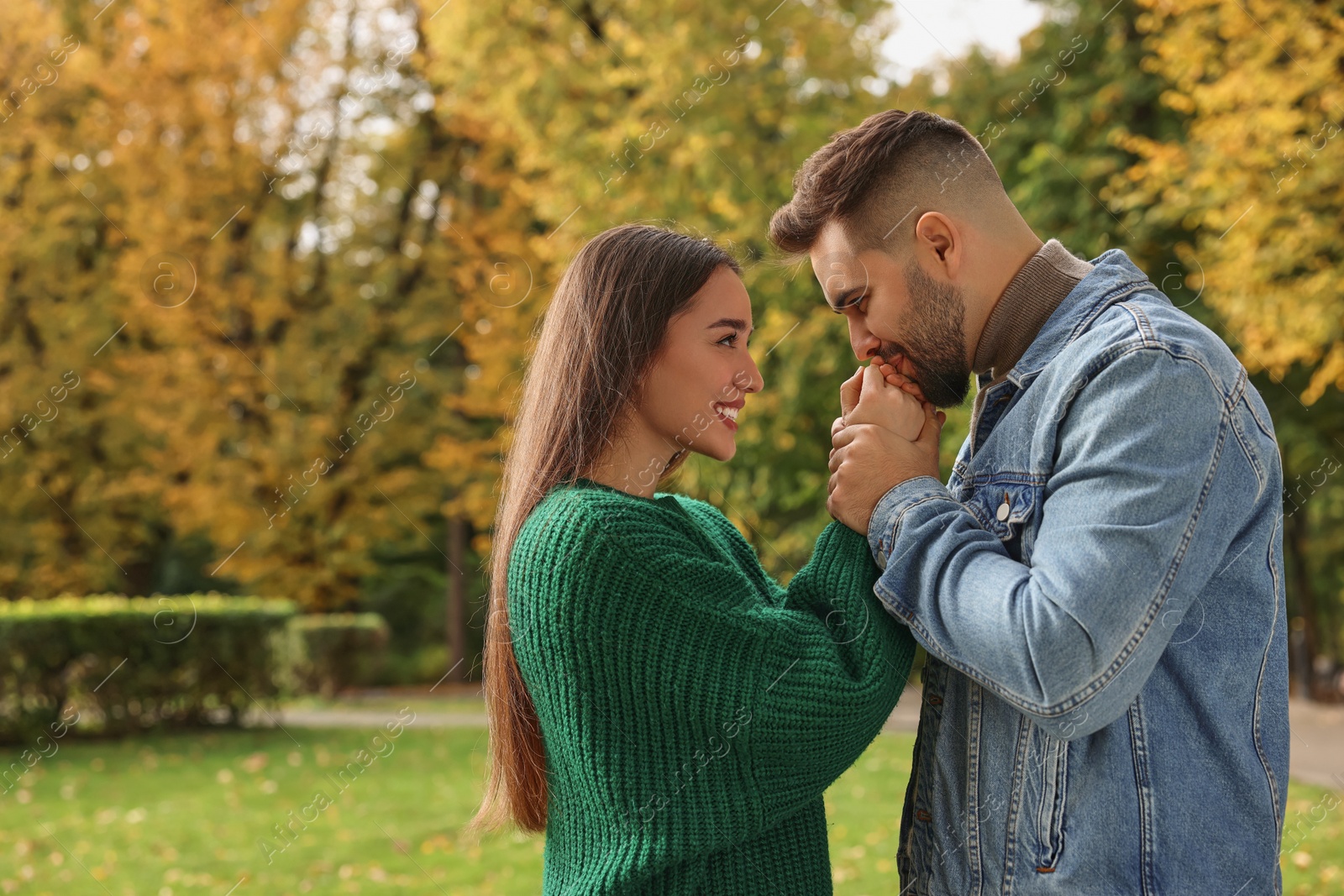 Photo of Romantic young couple spending time together in autumn park, space for text