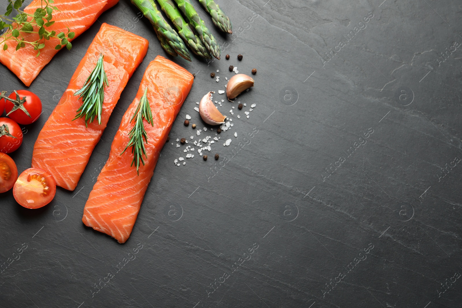 Photo of Fresh raw salmon and spices on black table, flat lay. Space for text