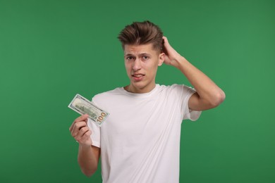 Photo of Upset man with dollar banknote on green background