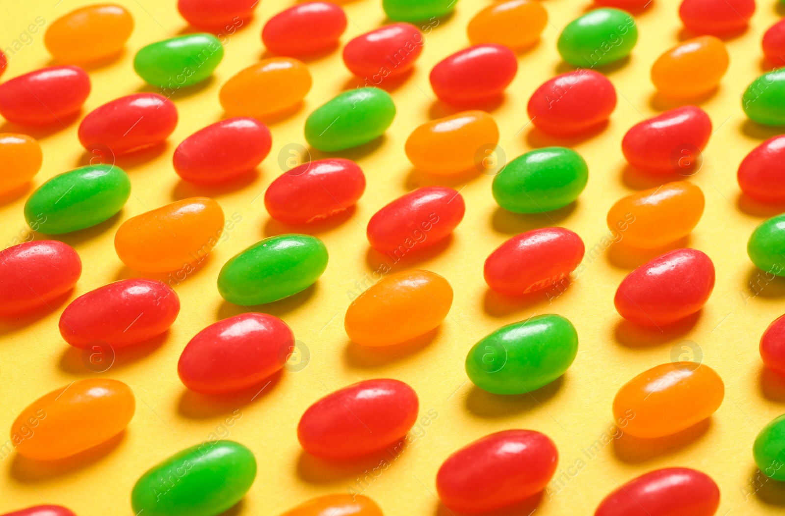 Photo of Delicious bright jelly beans on color background