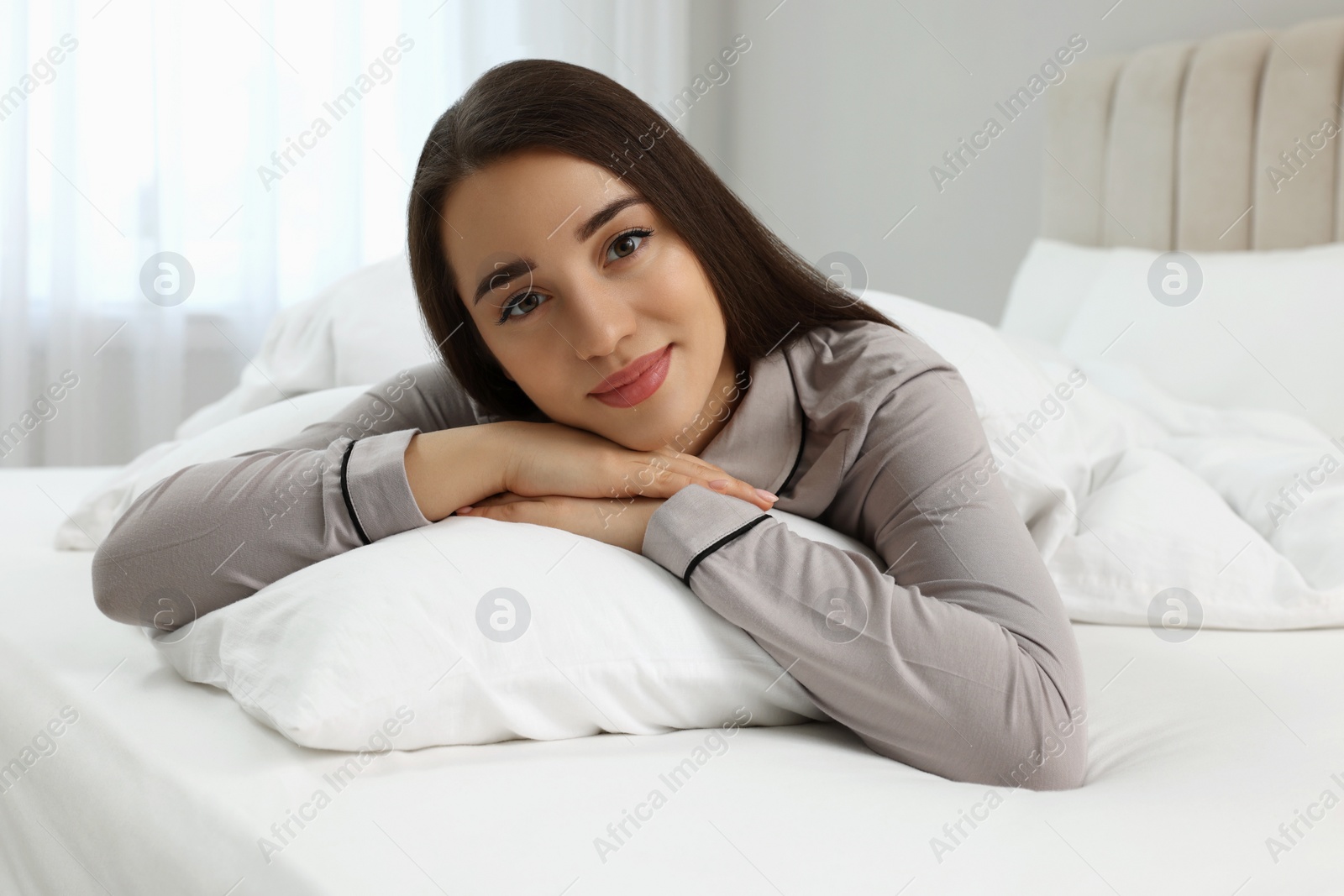 Photo of Beautiful young woman lying on bed at home