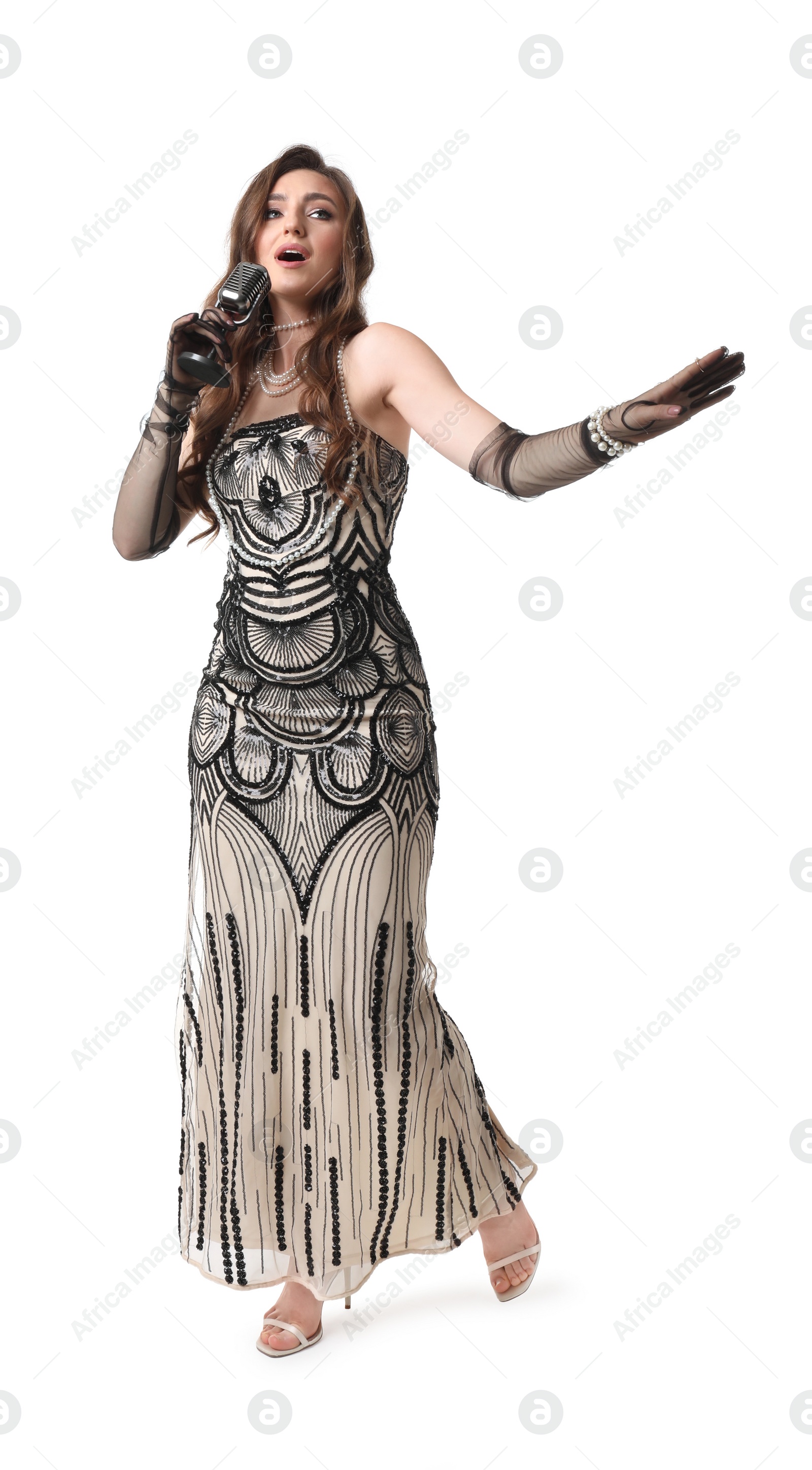 Photo of Beautiful young woman in stylish dress with microphone singing on white background