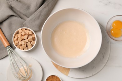 Different ingredients on white marble table, flat lay. Cooking delicious eggnog