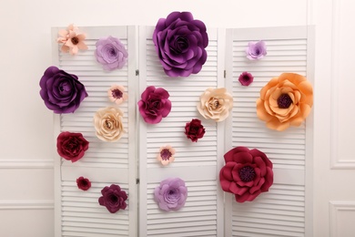 Beautiful paper flowers on folding screen indoors. Elegant photo zone