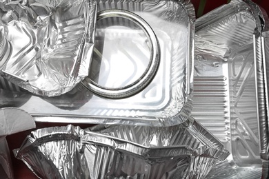 Photo of Pile of foil containers as background, top view. Recycling problem