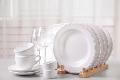 Photo of Set of clean tableware on light grey table