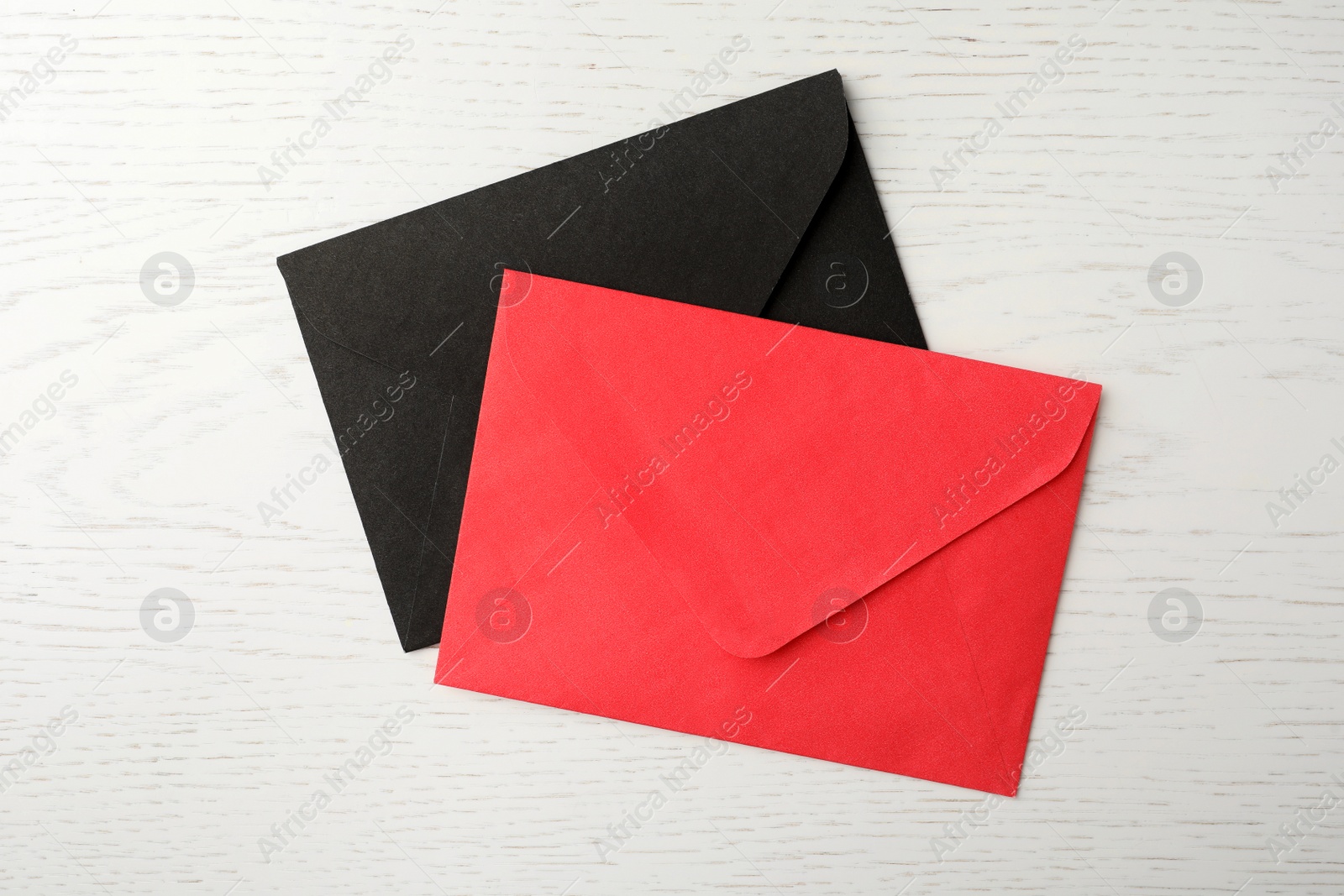 Photo of Paper envelopes on white wooden background, flat lay