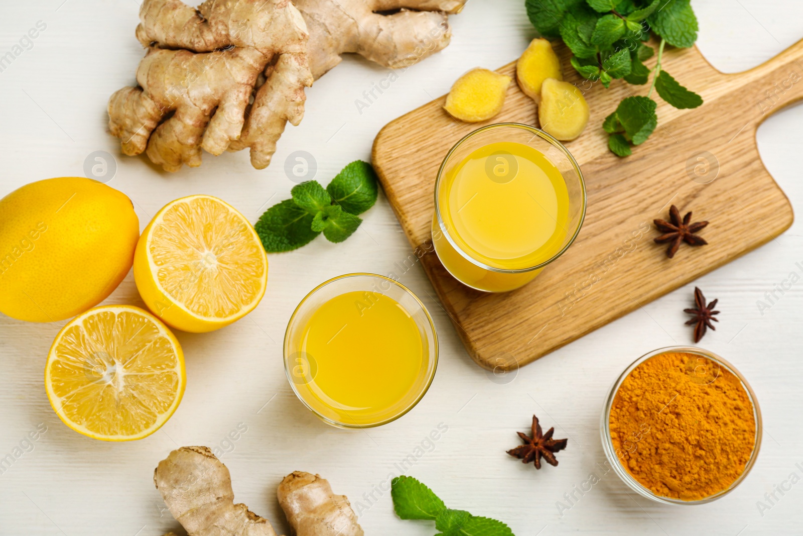 Photo of Flat lay composition with immunity boosting drink and ingredients on white wooden table