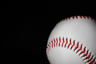 Photo of Baseball ball on black background, closeup. Space for text