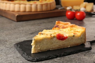 Photo of Piece of delicious homemade cheese quiche on gray table