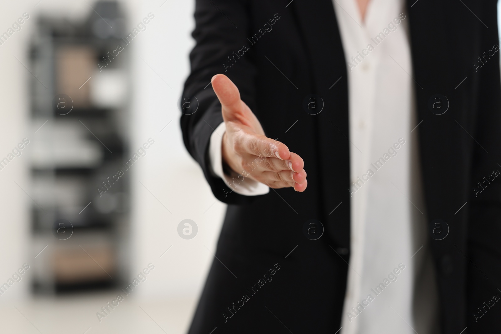 Photo of Woman welcoming and offering handshake indoors, closeup, space for text