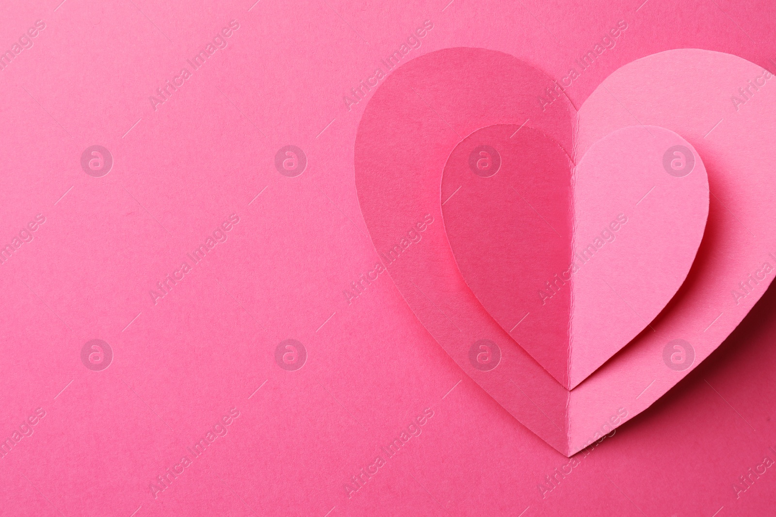 Photo of Paper hearts on pink background, top view. Space for text