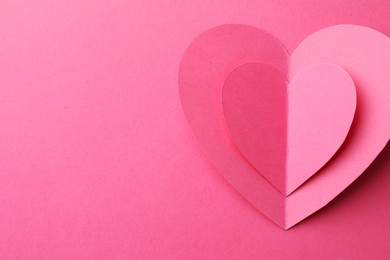 Paper hearts on pink background, top view. Space for text