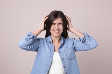 Photo of Portrait of stressed young woman on light background