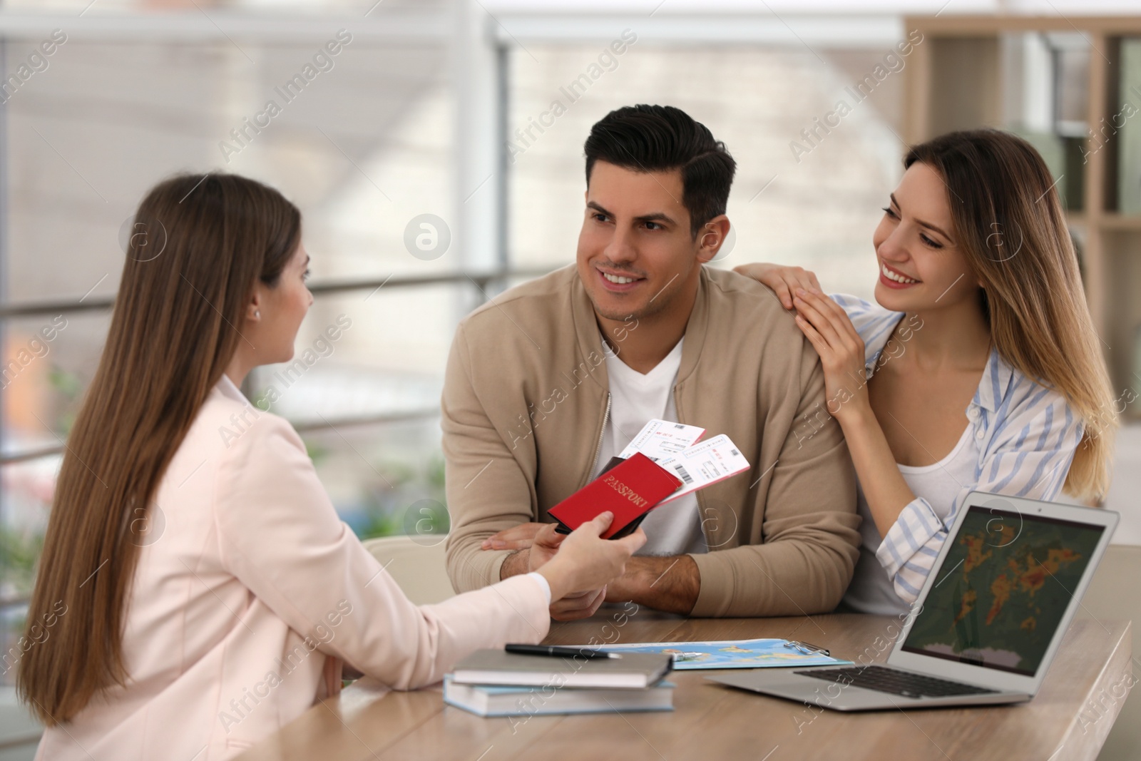 Photo of Travel agent giving tickets and passports to clients in office