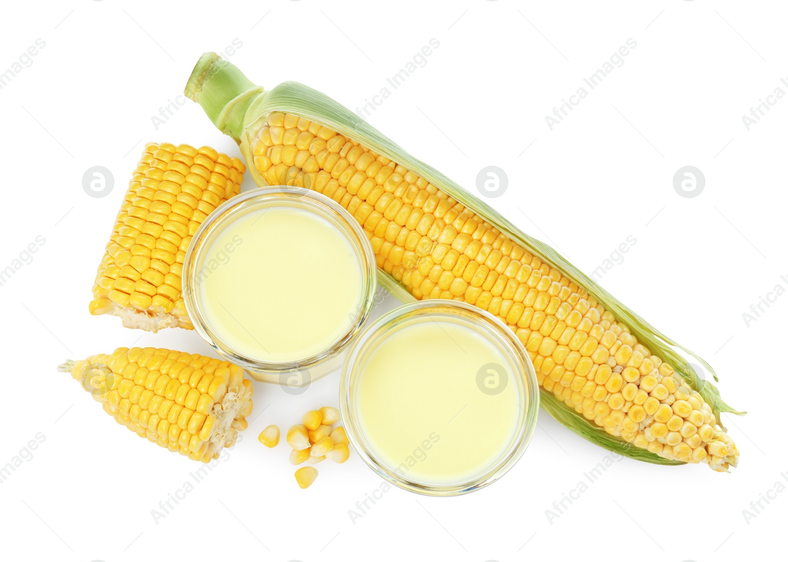 Photo of Tasty fresh corn milk in glasses and cobs on white background, top view