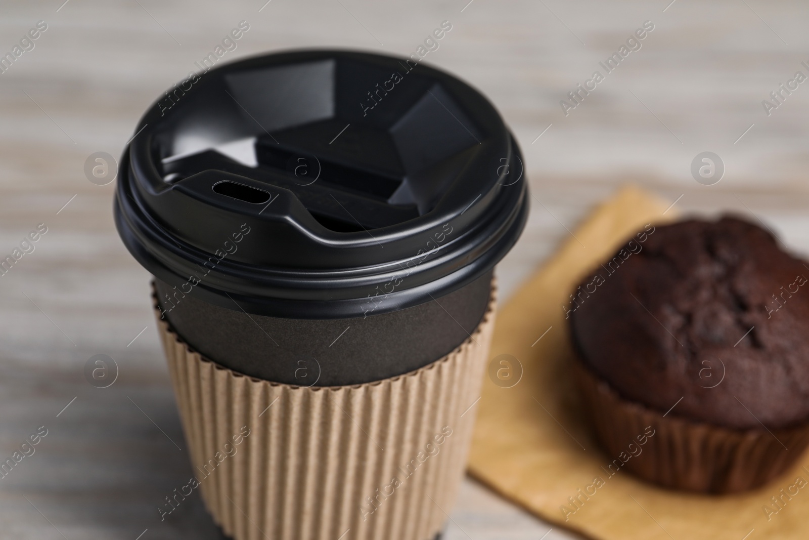 Photo of Paper cup with black lid on table, closeup. Coffee to go