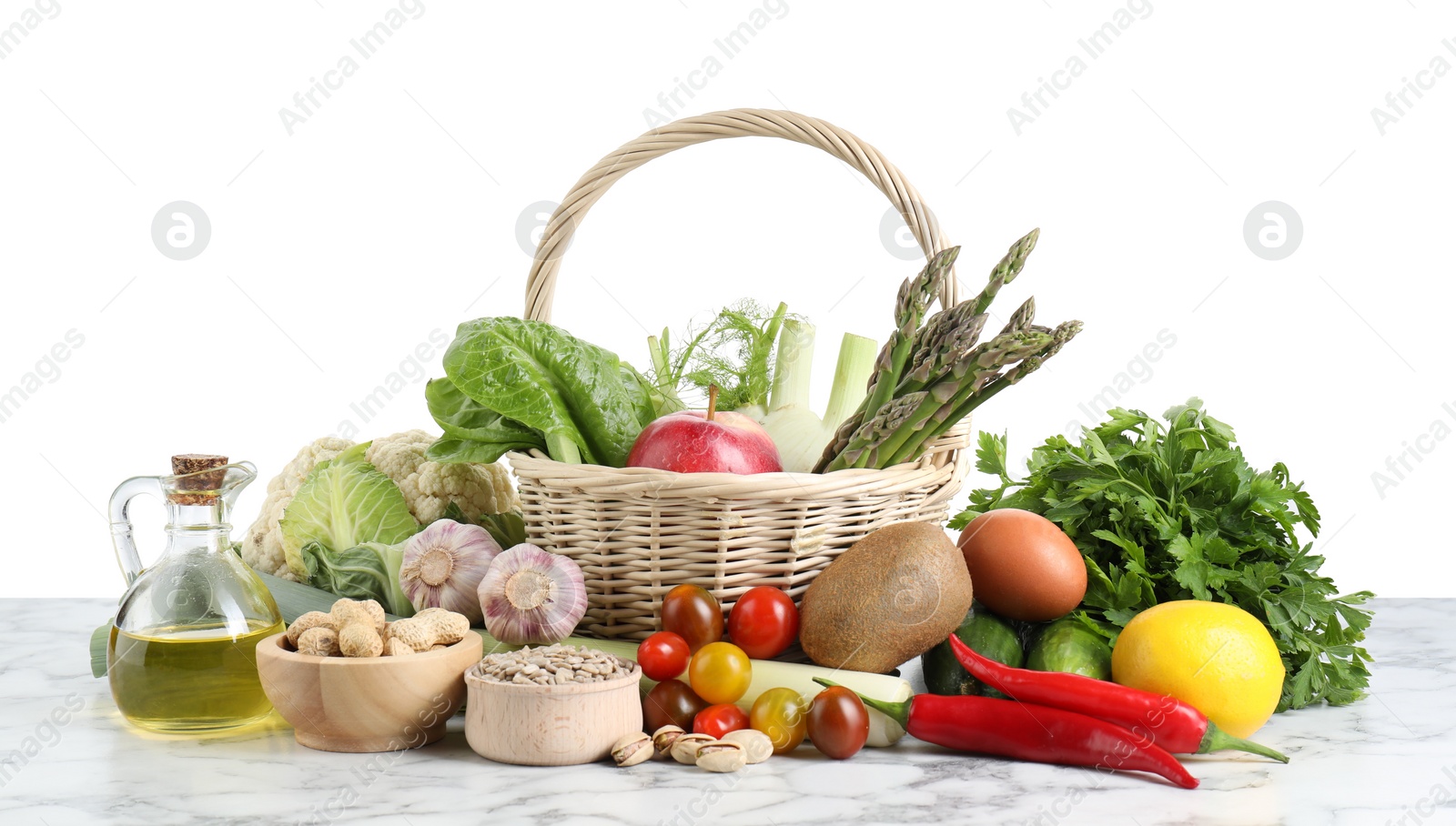 Photo of Healthy food. Basket with different fresh products on marble table against white background