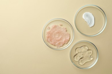 Many Petri dishes and cosmetic products on beige background, flat lay. Space for text