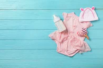 Photo of Flat lay composition with baby clothes and accessories on wooden background. Space for text