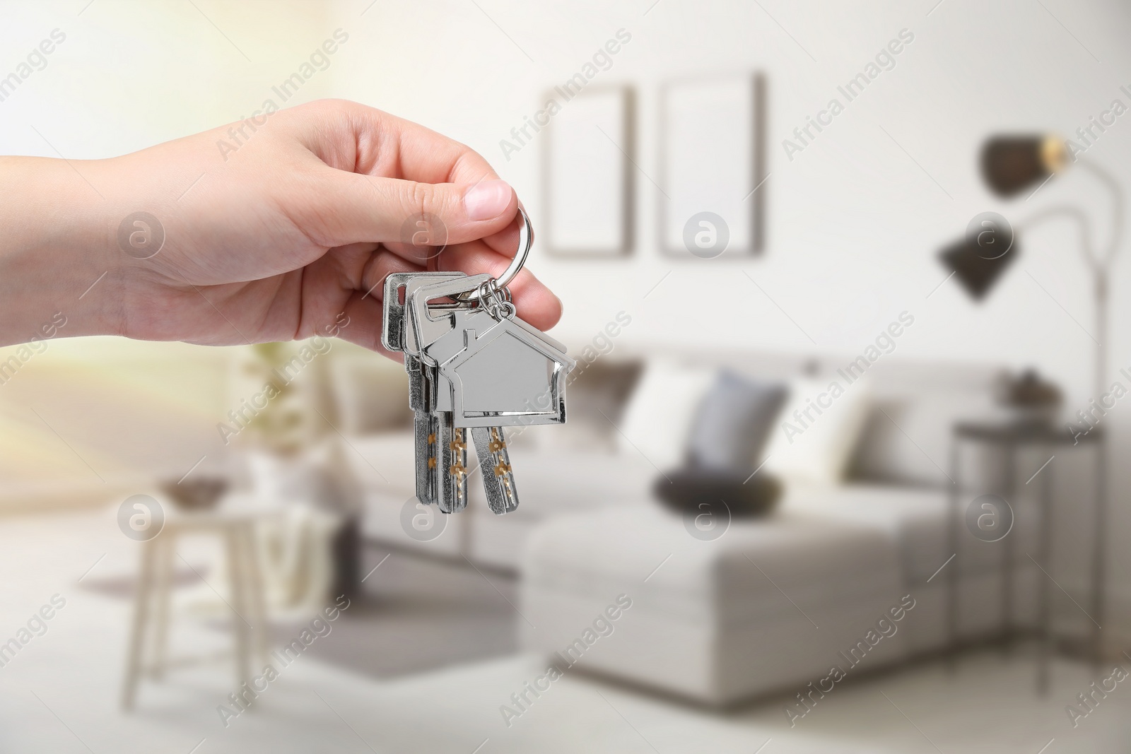 Image of Woman holding house keys in room, closeup