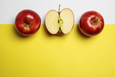 Flat lay composition with ripe juicy red apples on color background, space for text