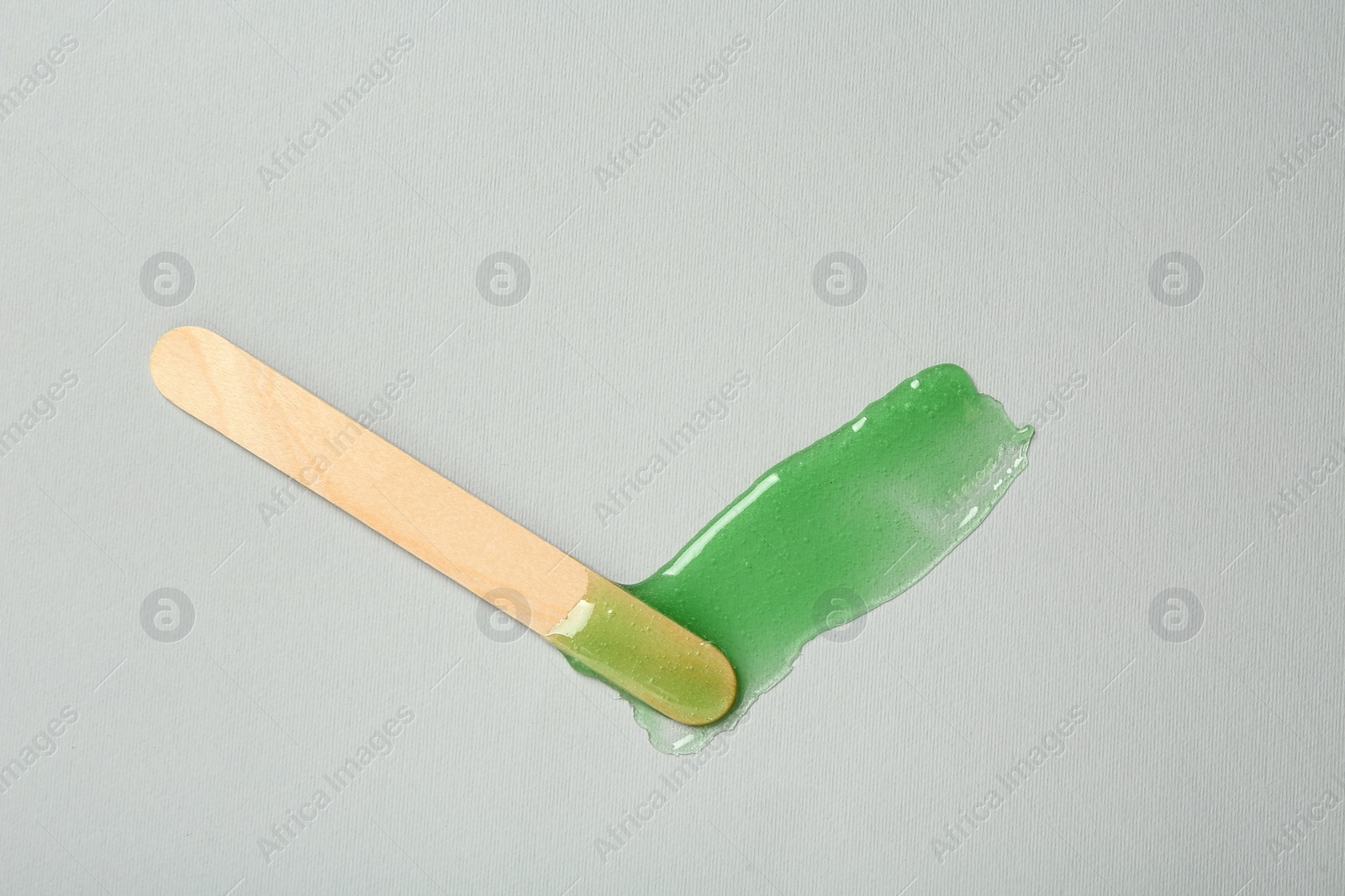 Photo of Spatula with wax on grey background, top view