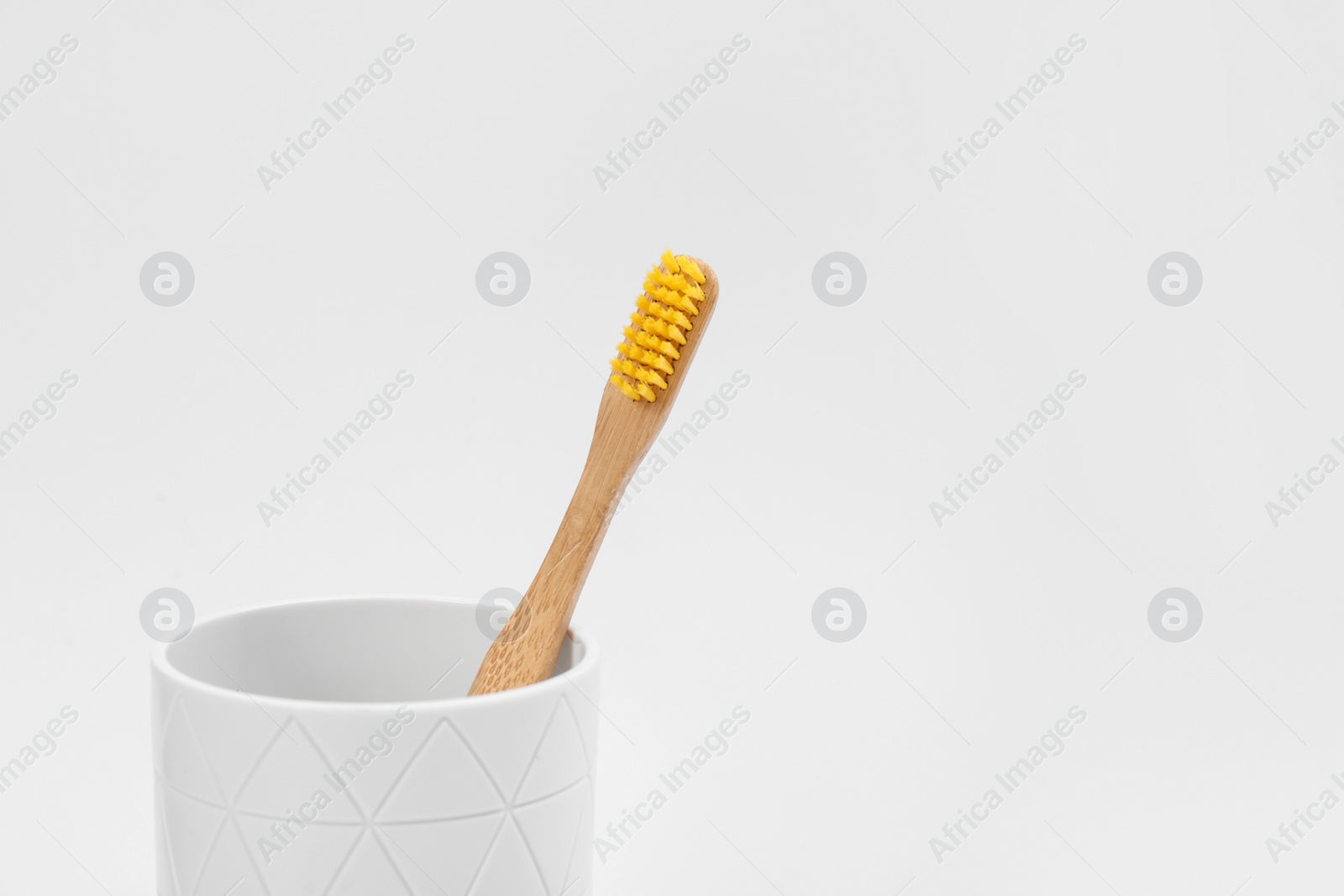 Photo of Bamboo toothbrush in holder isolated on white